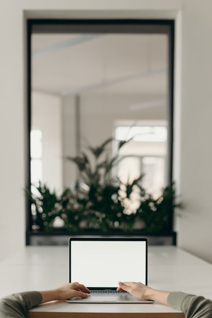 A modern home office setting with a laptop and plants creating a productive workspace.